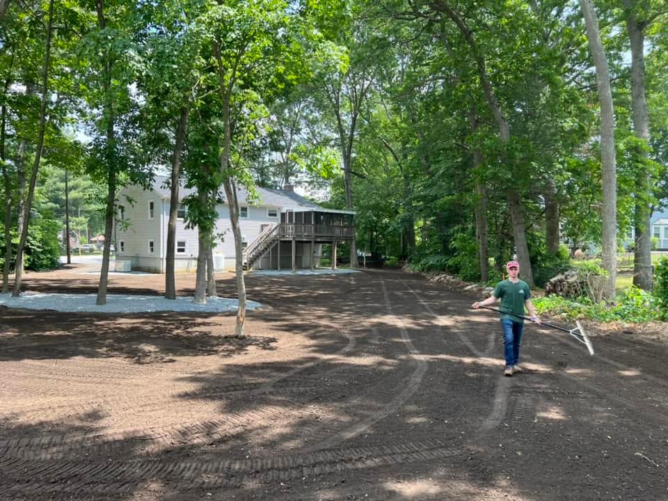 Parker crew member completing final grading in a wooded backyard