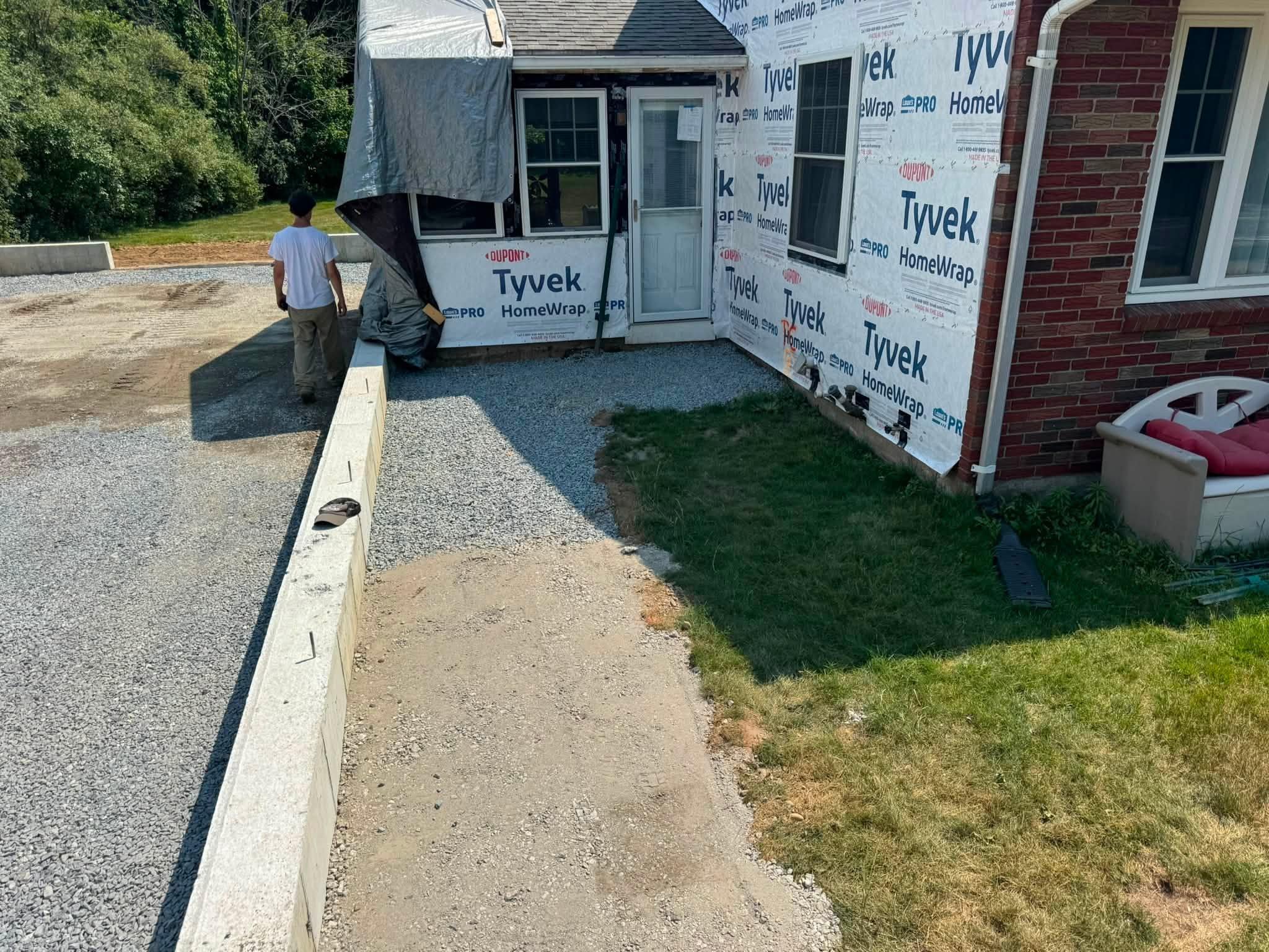 Prepared gravel base running beside an existing home