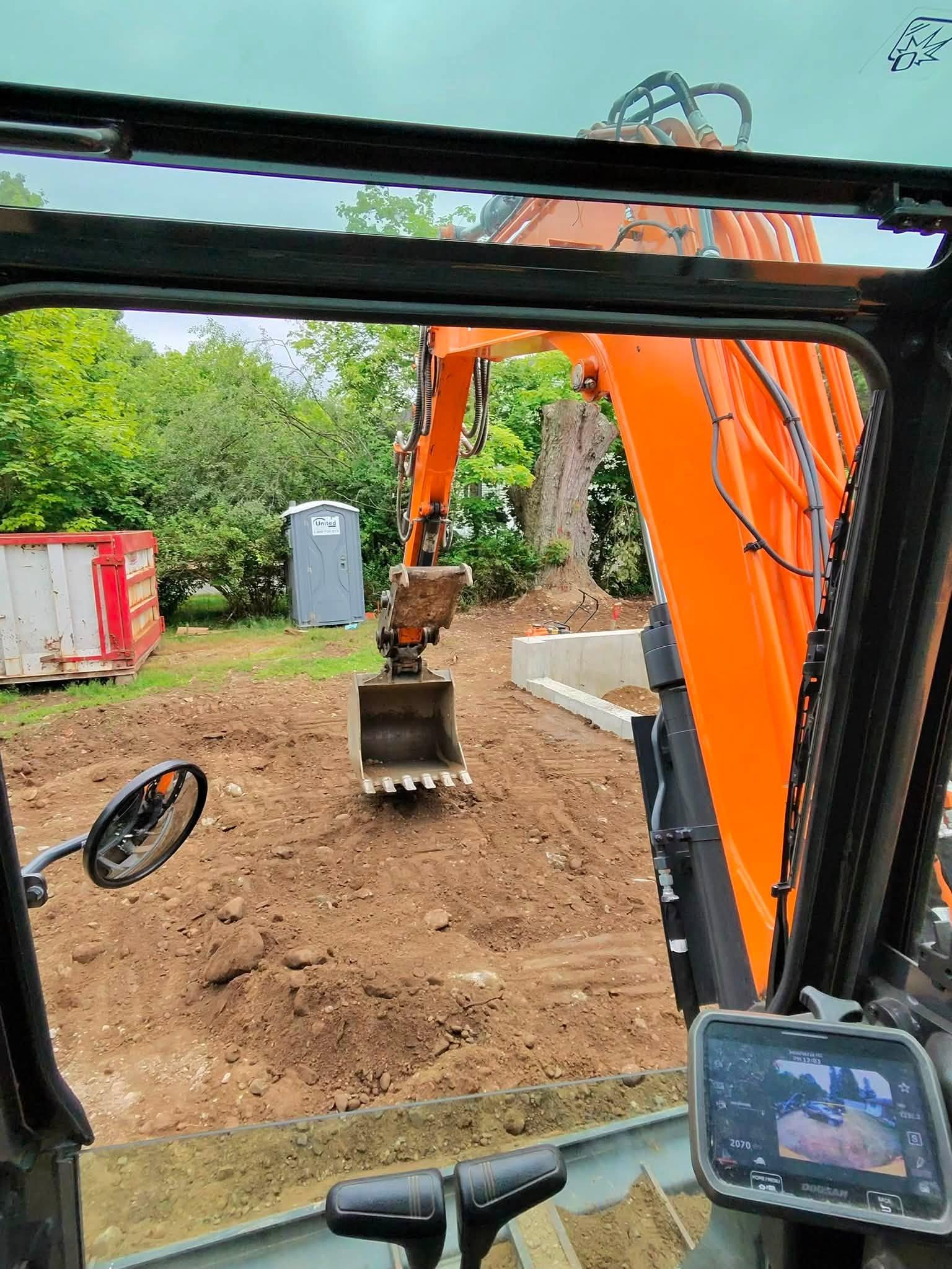 Residential addition site viewed from inside the excavator cab